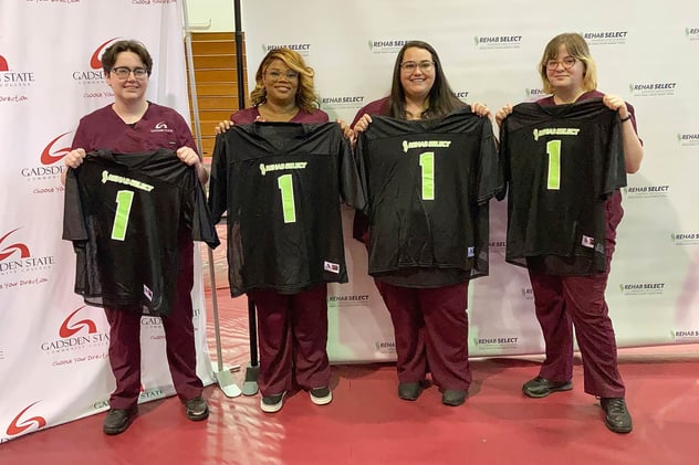 Gadsden State Nursing Students hired as apprentices at Rehab Select show off their jerseys at the signing day celebration.