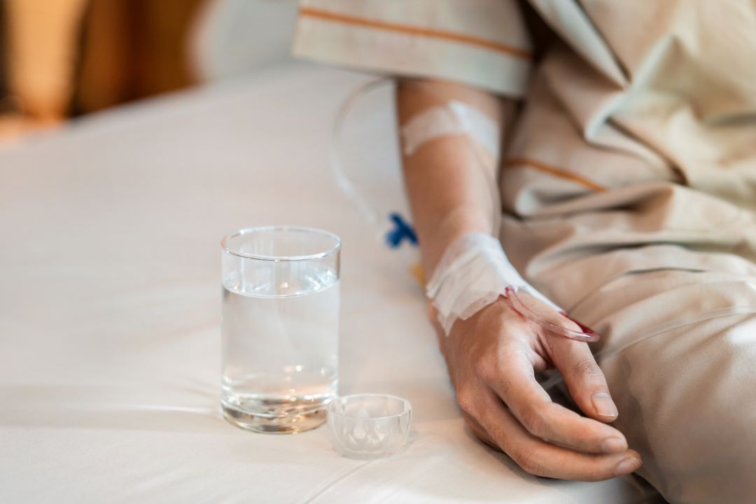 man patient with medical drip or IV drip drinking water with medicine 